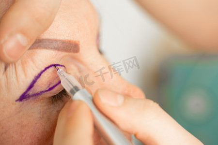 眼部健康摄影照片_整形手术前面部的眼睑标记特写，用于在医疗诊所修改面部眼部区域。