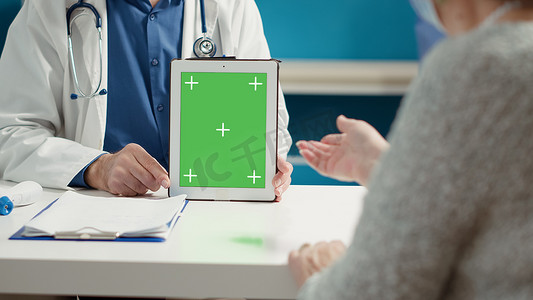 持有带绿屏的数字平板电脑的医疗专家