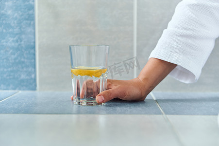 特写女人手拿着一杯新鲜的抗氧化剂柠檬水。