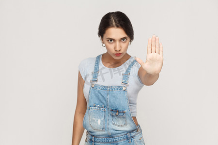 女人用手掌向外做出停止手势，表示不，表达拒绝或限制。