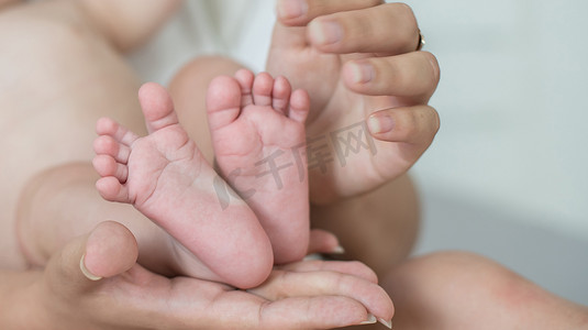 可爱手脚摄影照片_父母握着新生婴儿的手脚