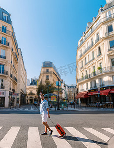 巴黎城市旅行的年轻人，带着手推车行李旅行的男人