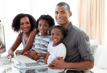 快乐的非洲裔美国家庭在家里用电脑工作