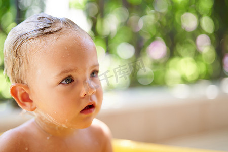 衣服泡在水里摄影照片_湿头发的小女孩坐在一碗水里