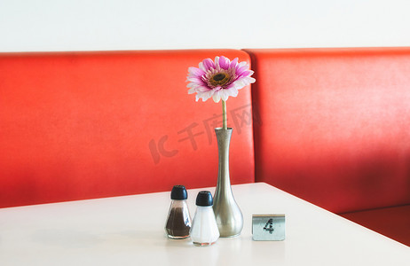 花标记摄影照片_咖啡厅的室内餐桌布置有花盆、盐和胡椒瓶和金属数字标记