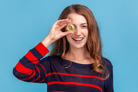 女人用黄金比特币遮住眼睛，表情积极，加密货币。