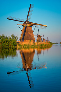 风车的摄影照片_荷兰小孩堤防的风车。
