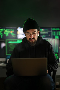 黑客使用笔记本电脑在全球范围内组织恶意软件攻击。垂直图像。
