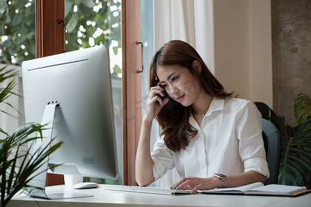 迷人聪明的亚洲女企业家的侧视图在家庭办公室使用计算机工作培训公司职业发展研讨会。