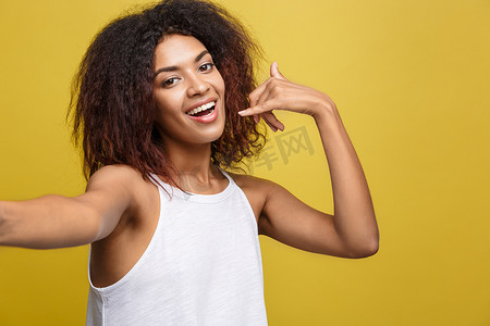 特写镜头快乐的年轻美丽的非洲裔美国女人自己自拍并手工制作电话符号。