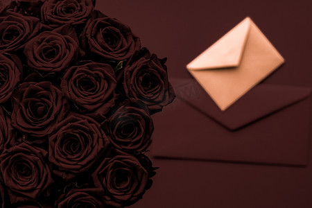 情人节送情书和鲜花，奢华的玫瑰花束和巧克力背景的卡片，适合浪漫的假日设计