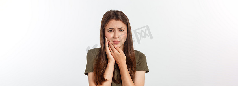 人痛苦的表情摄影照片_十几岁的女人用痛苦的表情按压她瘀伤的脸颊，好像她牙痛得厉害