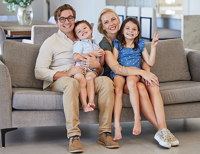 母亲、孩子和父亲在一个可爱的家里的沙发上，在一张幸福的全家福中，在客厅里享受美好的时光。