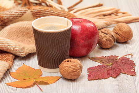 一杯咖啡、核桃、苹果和干树叶在秋天的静谧生活中。