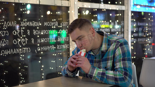 吃卷饼摄影照片_年轻人在一家餐馆吃卷饼。
