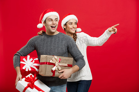 圣诞节概念 — 年轻漂亮的夫妇拿着很多礼物，喜欢在圣诞节购物和庆祝
