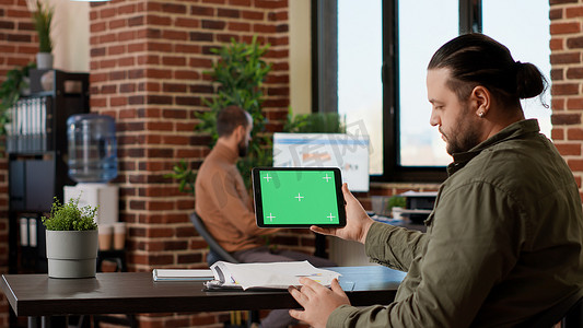 男性自由职业者在平板电脑上使用水平绿屏显示