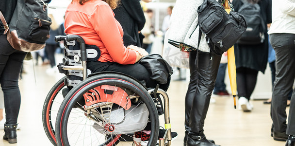线性任务摄影照片_坐在轮椅上排队等待执行日常任务的面目全非的残障妇女的特写。