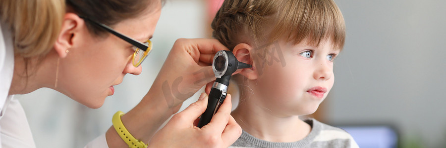 身体疼痛摄影照片_耳鼻喉科医生对小女孩耳朵进行身体检查