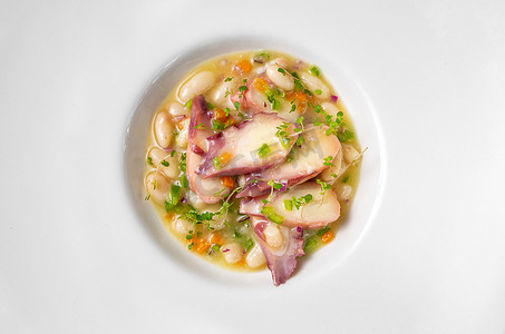 俯拍的盘子摄影照片_俯拍的章鱼静物与白豆和蔬菜。