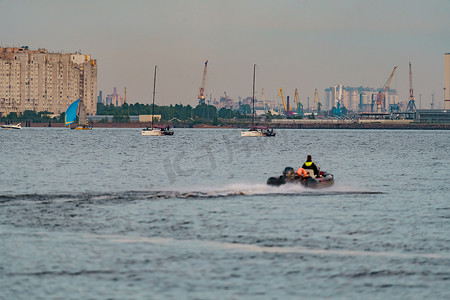 海港、建筑起重机和货港起重机在日落光下的海平线上