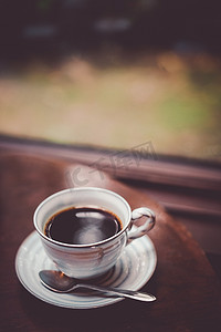 下雨喝茶摄影照片_靠窗的桌子上放着咖啡