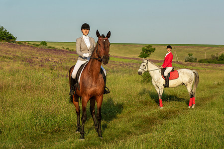 两名年轻女子在公园里骑马。
