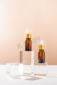 琥珀色玻璃滴管瓶，在玻璃讲台和米色背景上带有带白色橡胶尖头的吸管，模型设计