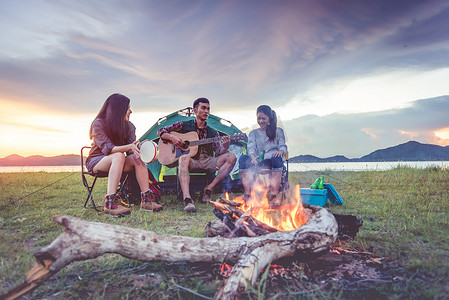 一群旅行者一起露营、野餐和演奏音乐。