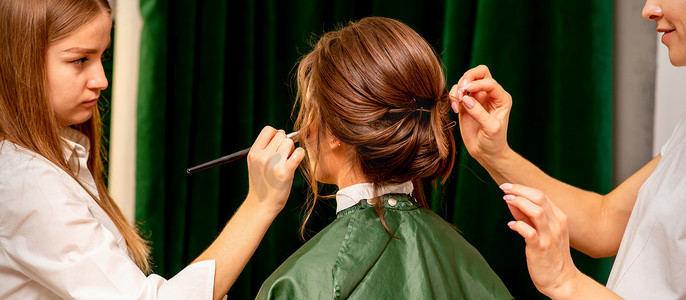 做发型摄影照片_化妆师和美发师在美容院为新娘做发型和化妆做准备。