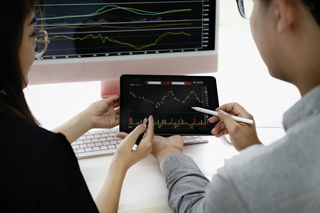 两会报告分析摄影照片_投资专家用笔指着平板显示器分析股市，教你如何盈利。