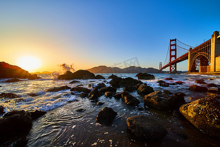旧金山金门大桥日落时海浪拍打岩石