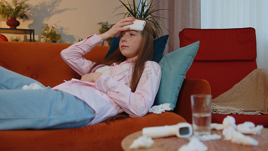 生病的孩子患感冒或过敏，躺在家里的沙发上打喷嚏，把鼻涕擦进餐巾纸
