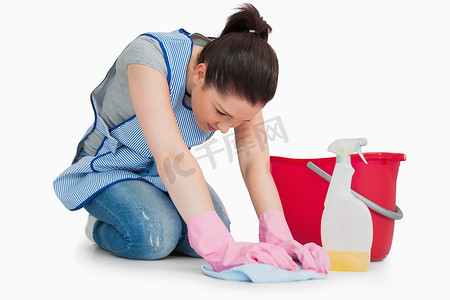严肃的清洁女工擦地板