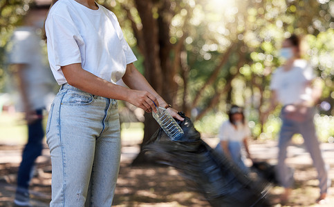 志愿者在户外社区清理项目中帮助收集垃圾，收集塑料和废物进行回收。