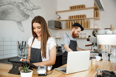 员工电脑摄影照片_咖啡经营理念-美丽的白种人调酒师咖啡师或经理在现代咖啡店的数字平板电脑菜单中发布订单。