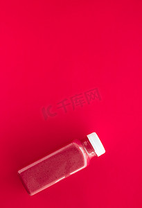 巧克力平面设计摄影照片_排毒超级食品草莓冰沙瓶，用​​于减肥清洁。红色背景，食品和营养专家博客的平面设计