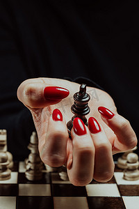 在棋盘智力游戏中，女人手里拿着对手的棋王。