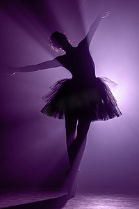 穿着芭蕾舞短裙表演、在舞台上跳舞的芭蕾舞演员的剪影。