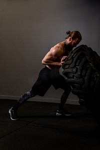 防抱死制动系统摄影照片_健身男轮健身房肌肉轮胎男子翻转强力训练，从集中推力、健康举重中获得锻炼力量。