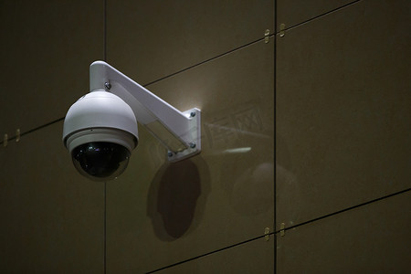 夜间建筑物墙上的 360 度球监控安全摄像头