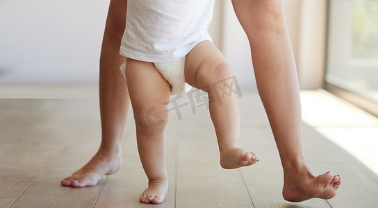 开门走路摄影照片_宝宝正在学习和走路，孩子在家里和妈妈一起迈出了学习走路的第一步。