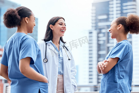 身穿实验服的年轻白人医生站在外面，与穿着手术服的混血护士交谈。