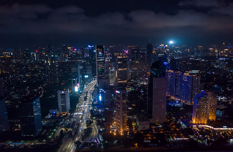 2021年印度尼西亚雅加达黑暗中的现代大都市市中心，夜间有摩天大楼，城市灯光和高速公路交通