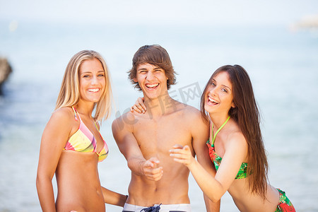 三个年轻漂亮的朋友在海滩上玩得很开心