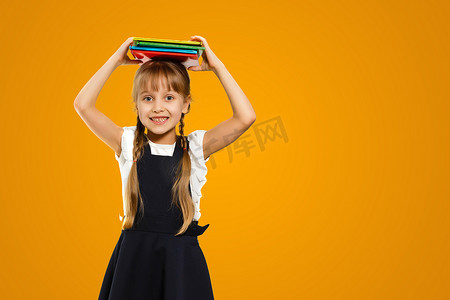 一个快乐聪明的白人青少年女学生穿着书包回到学校接受黄色背景中的新学术教育年的特写镜头。