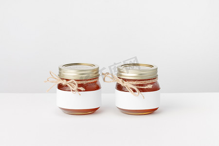 两个罐子，配有蜂蜜、麻线和白色标签