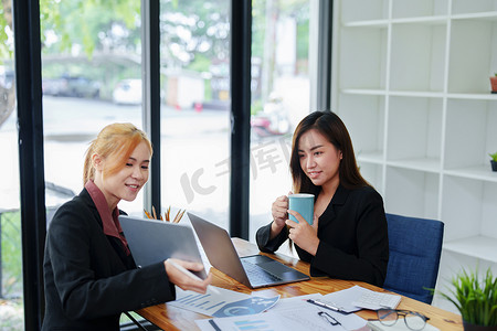 咨询摄影照片_一位年轻亚洲女商人的肖像咨询、规划营销以提高客户的产品质量