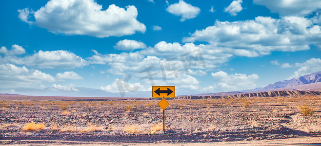 方向标志摄影照片_方向标志在沙漠与风景秀丽的蓝天和广阔的地平线。