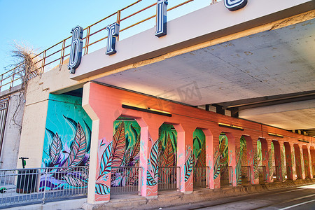 彩色羽毛摄影照片_城市桥下的隧道被彩色羽毛涂鸦覆盖